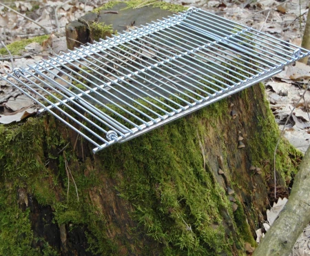 Składany ruszt na ognisko (grill turystyczny) Fox Outdoor stalowy 38x25 cm - złożony na pniaku drzewa w lesie