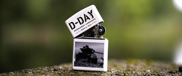 Kolekcjonerska zapalniczka Zippo D-DAY Landing, lekko otworzona na kamieniu